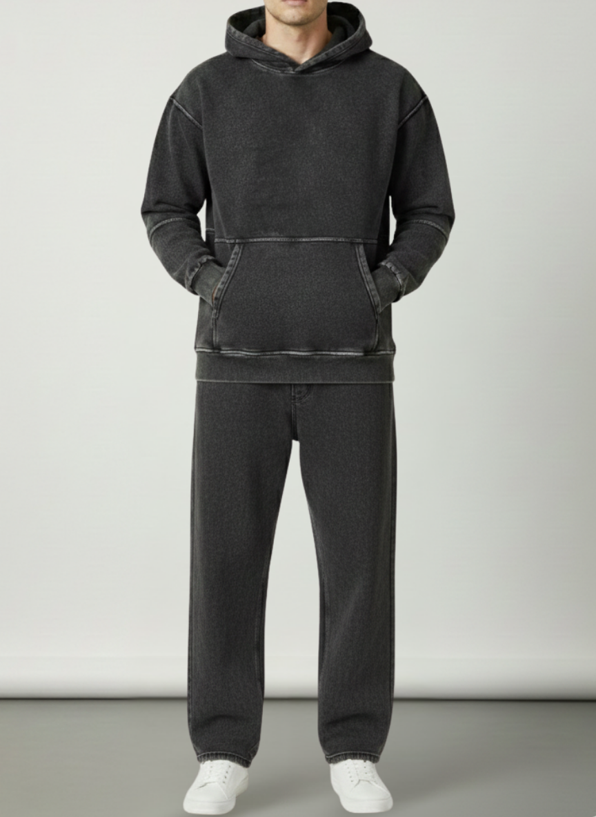 Person wearing a black hoodie and pants on a plain background