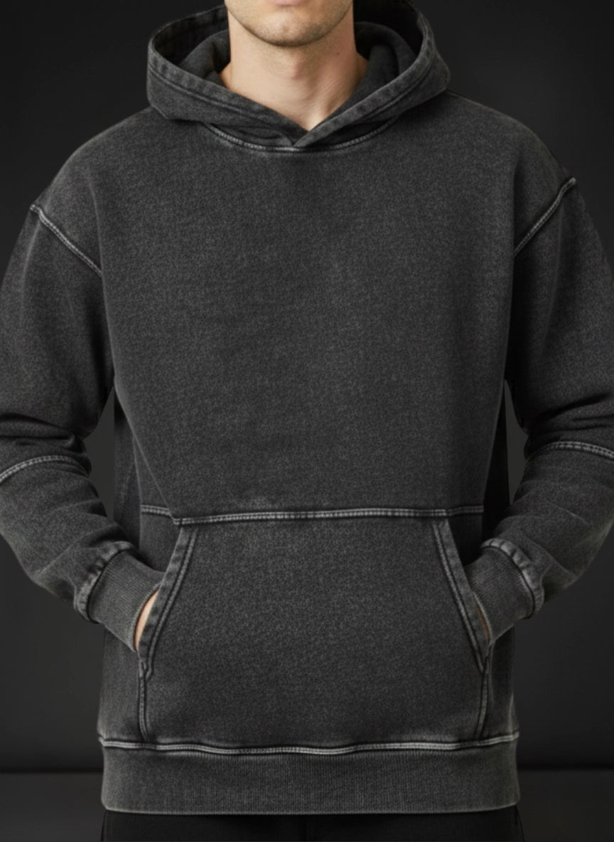 Person wearing a dark gray hoodie against a black background