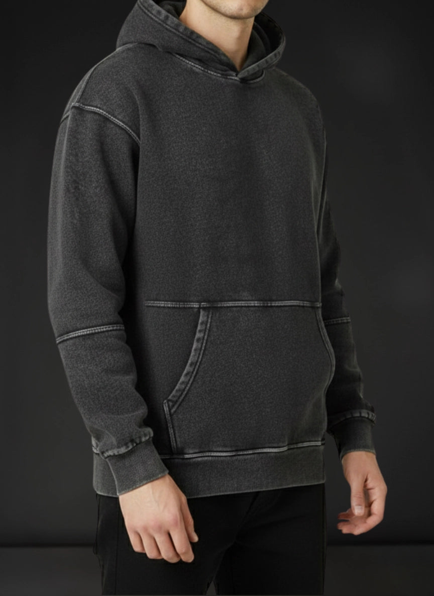 Person wearing a dark gray hoodie against a black background