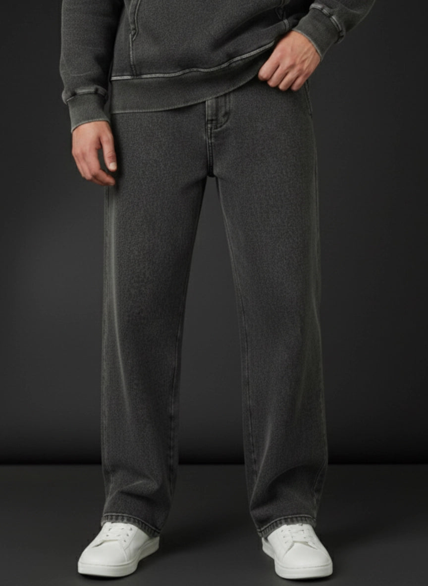 Person wearing dark gray trouser and white sneakers on a black background