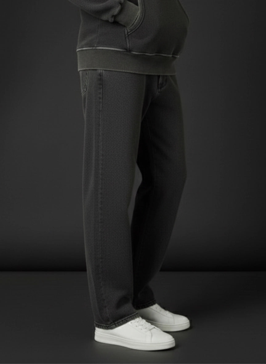 Person wearing dark gray sweatpants and white sneakers on a black background