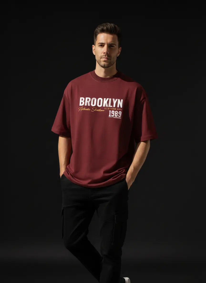 Man wearing a maroon t-shirt with BROOKLYN 1989 Oversized Cotton T-Shirt on a black background