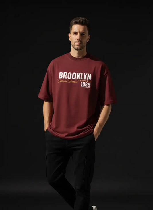 Man wearing a maroon t-shirt with BROOKLYN 1989 Oversized Cotton T-Shirt on a black background