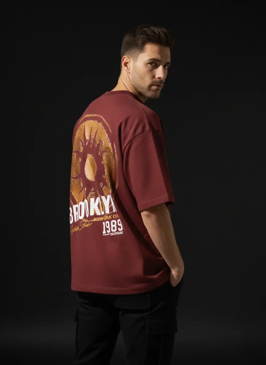 Man wearing a red t-shirt with a graphic design on the back against a black background