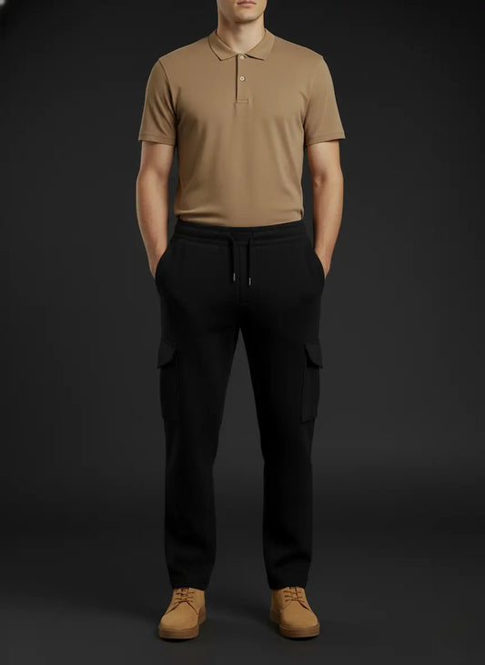 Person wearing a beige polo shirt and black scuba trouser on a dark background