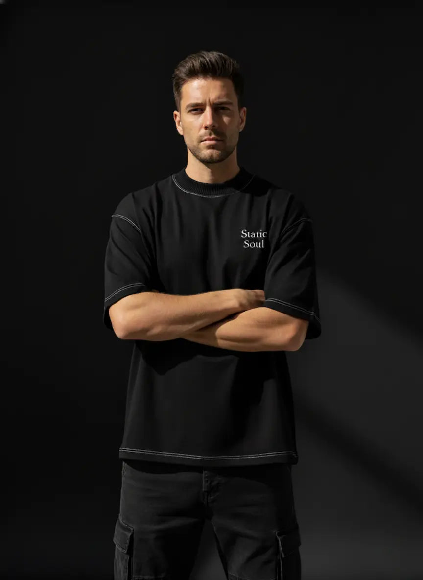 Man wearing a Black Oversized Cotton T-Shirt with 'Static Soul' text against a dark background