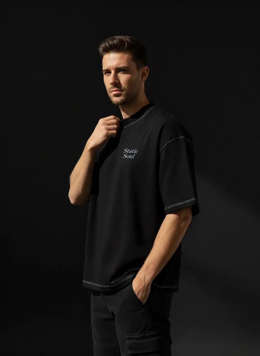 Man wearing a black t-shirt with text on a dark background