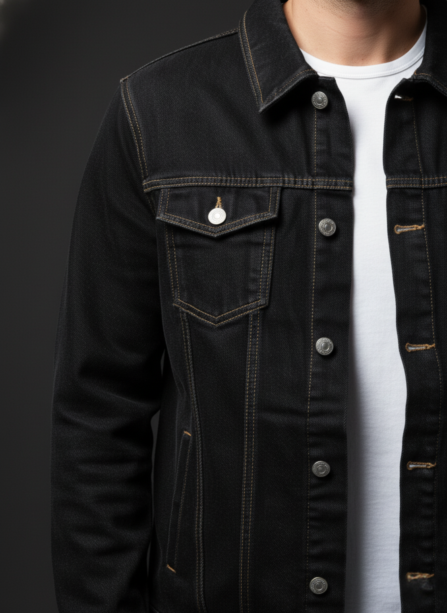 Black denim jacket worn by a person on a dark background