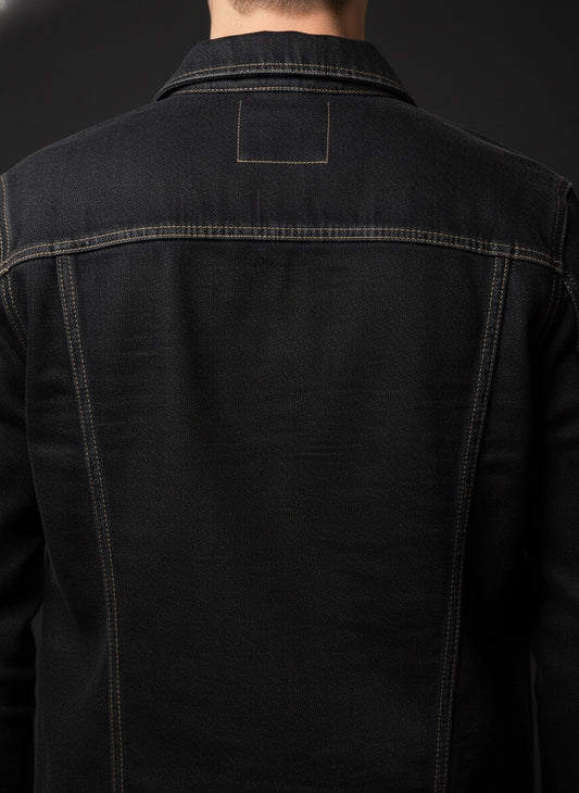 Black denim jacket with a brand logo on the chest against a dark background