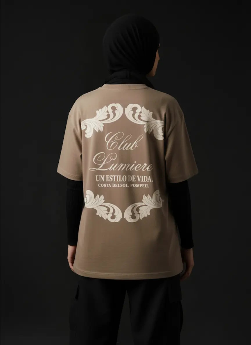 Person wearing a brown t-shirt with 'Club Lumiere' design on the back against a black background