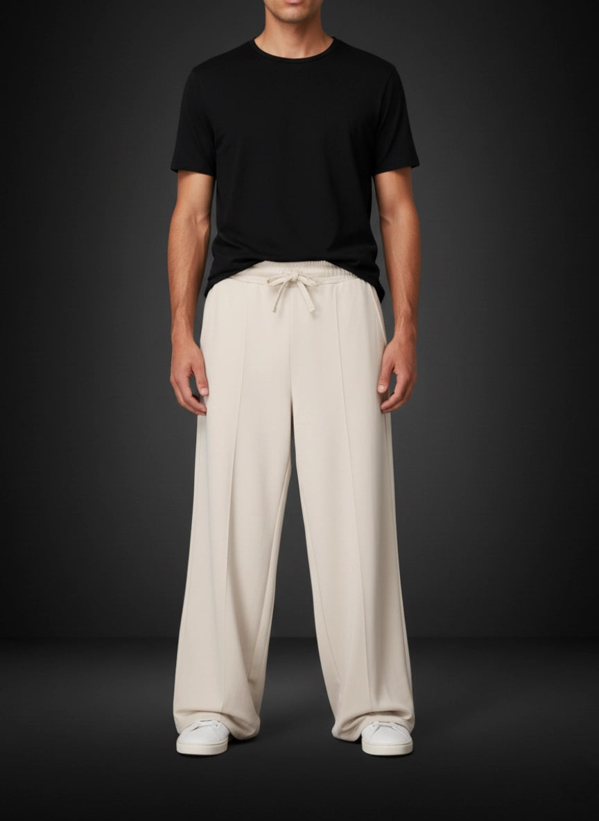 Person wearing a black t-shirt and beige wide-leg pants on a dark background