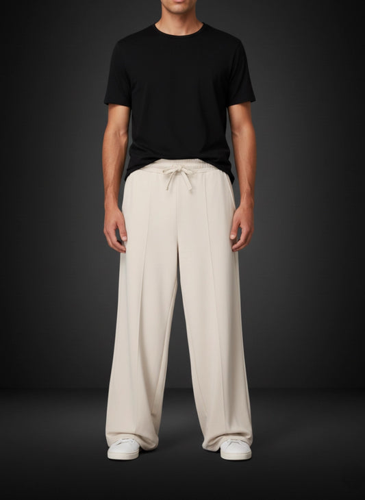 Person wearing a black t-shirt and beige wide-leg pants on a dark background