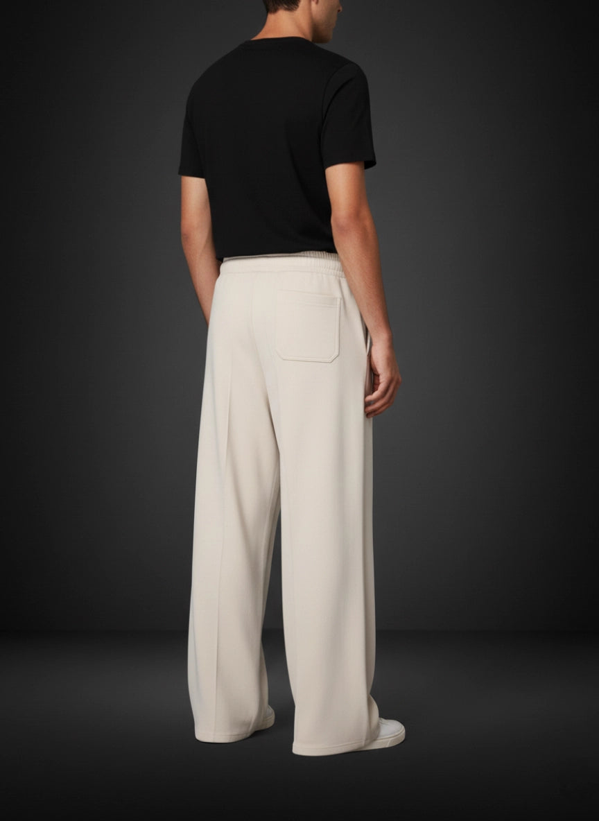 Person wearing a black t-shirt and beige wide-leg pants on a dark background