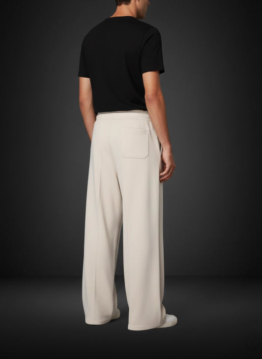 Person wearing a black t-shirt and beige wide-leg pants on a dark background