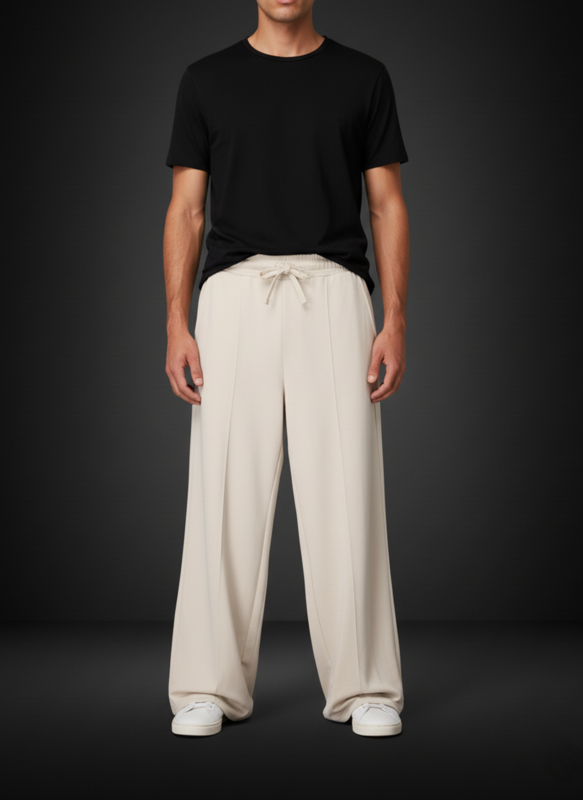 Person wearing a black t-shirt and beige wide-leg pants on a dark background
