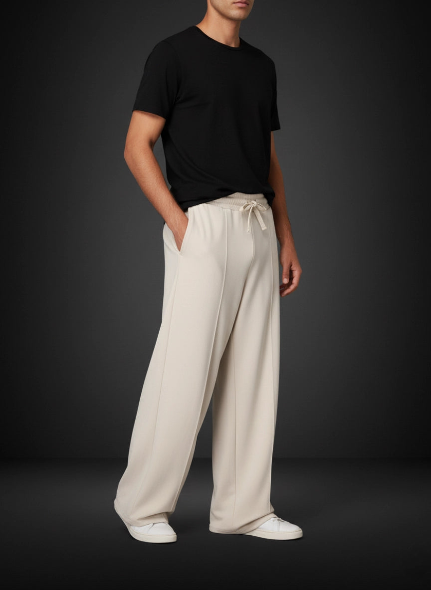 Person wearing a black t-shirt and white pants on a dark background