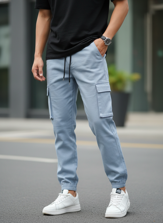 Person wearing light blue cargo pants and white sneakers on a street.