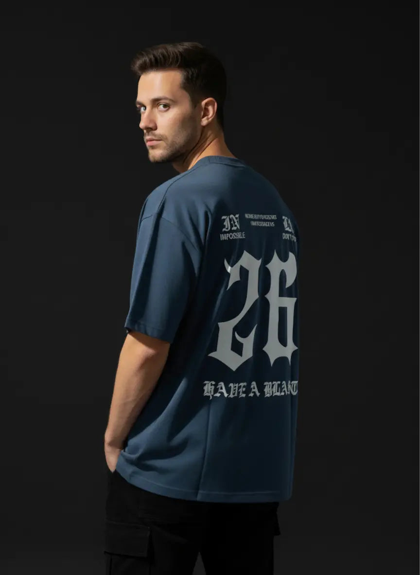 Man wearing a blue t-shirt with branding on the back against a black background