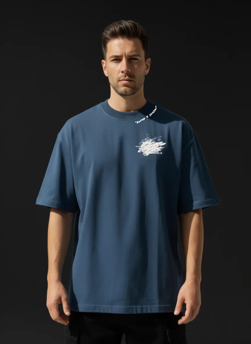 Man wearing a blue t-shirt with a logo on a black background