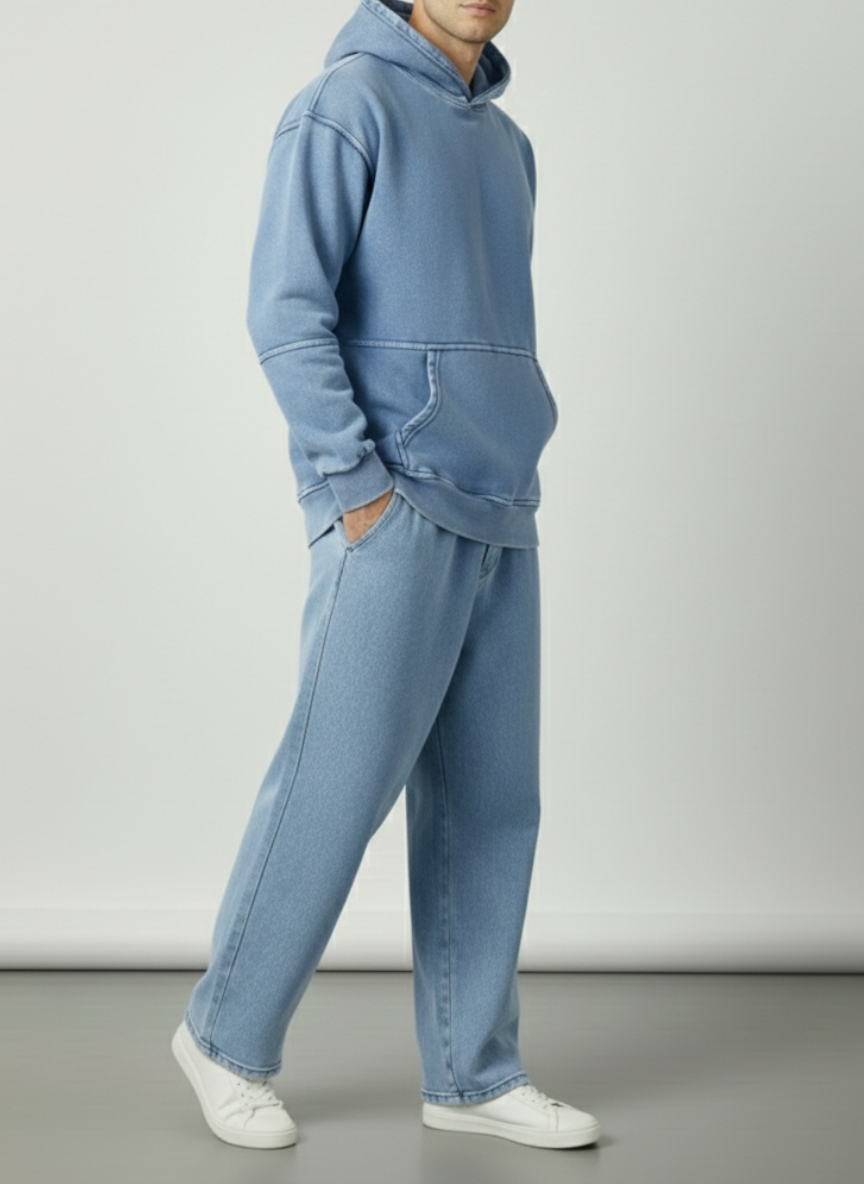 Person wearing a blue hoodie and jeans set on a plain background