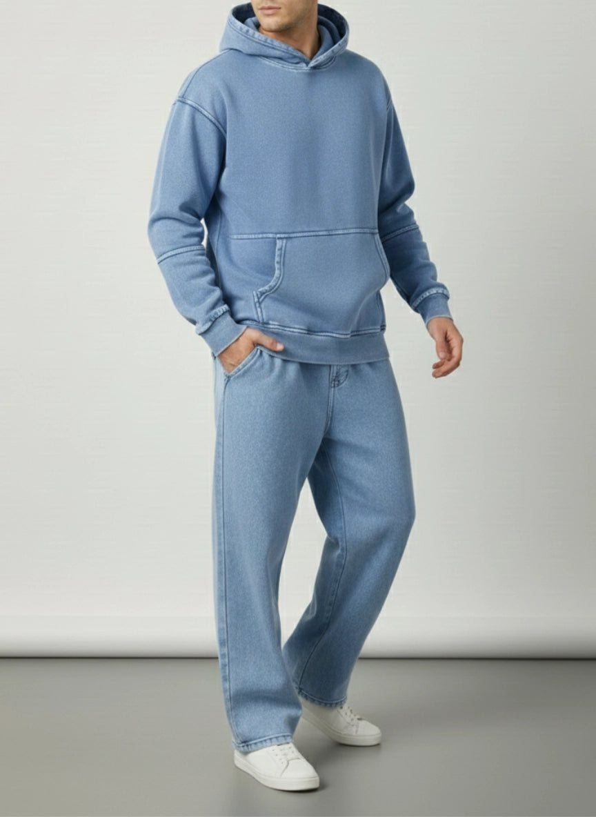 Person wearing a blue hoodie and jeans set on a plain background