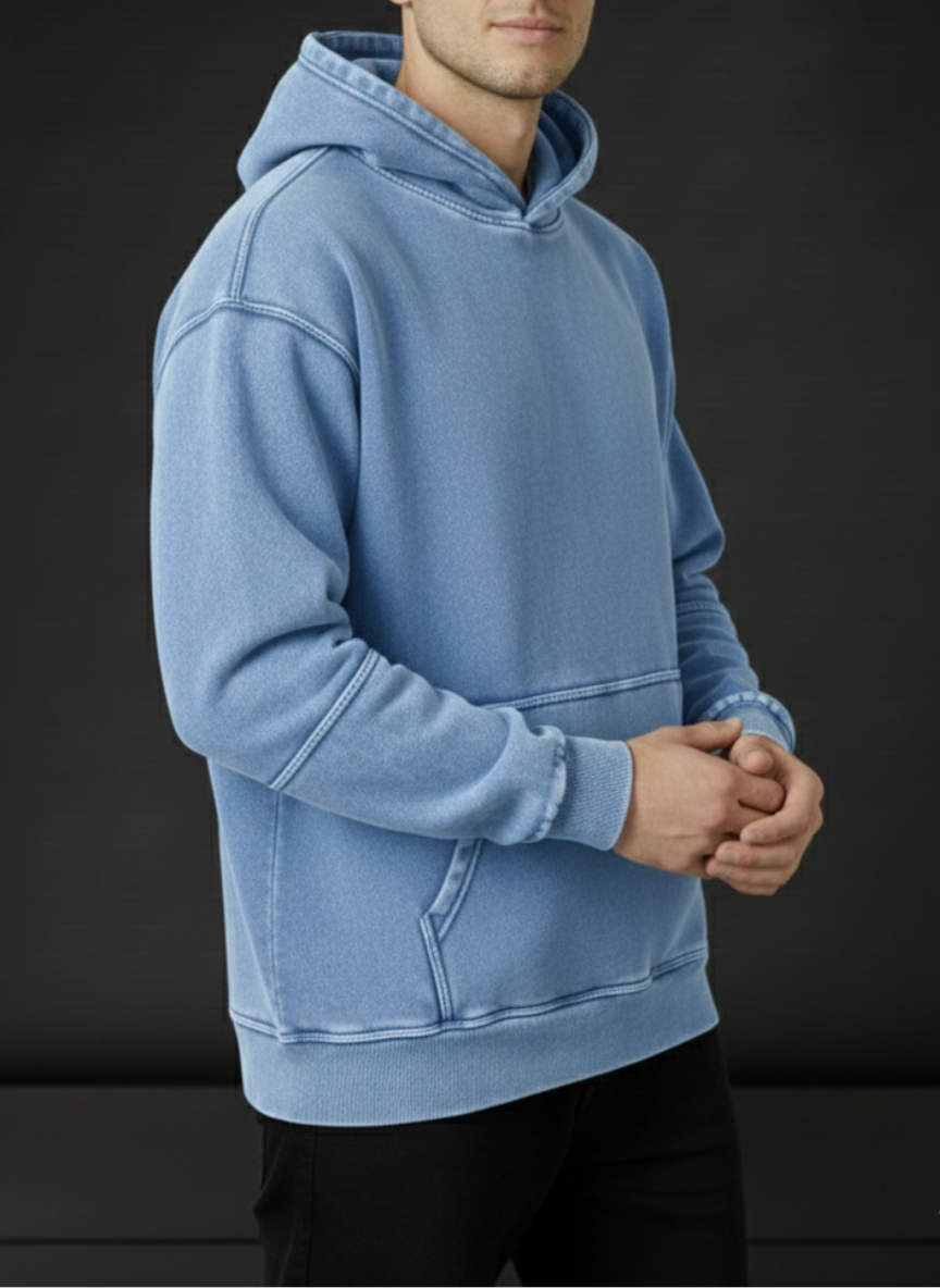 Person wearing a light blue hoodie against a dark background