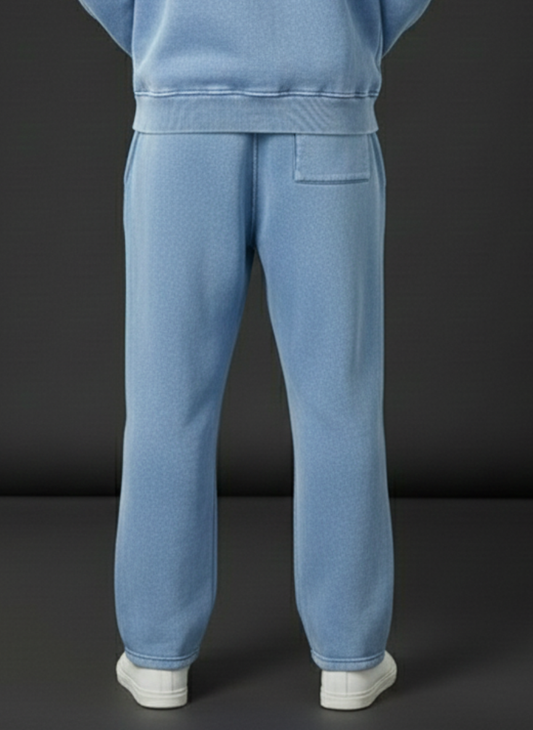 Light blue sweatpants worn by a person on a black background