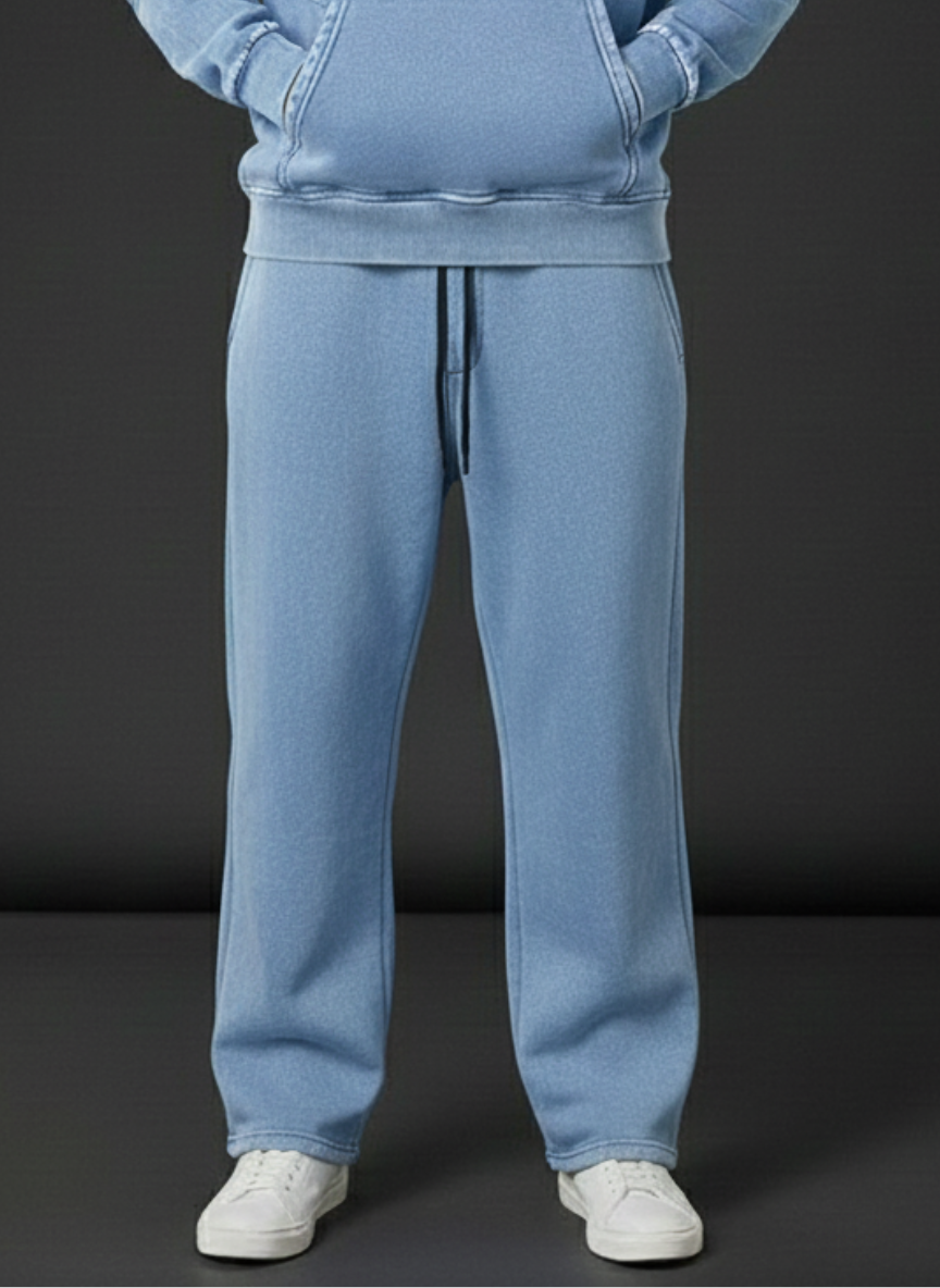 Person wearing a light blue tracksuit with white shoes on a dark background