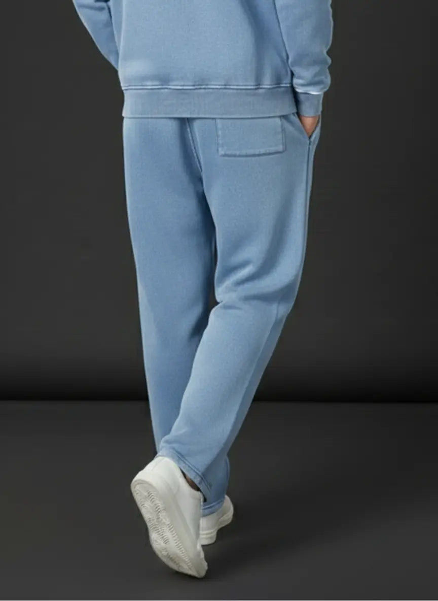 Person wearing a blue tracksuit against a black background