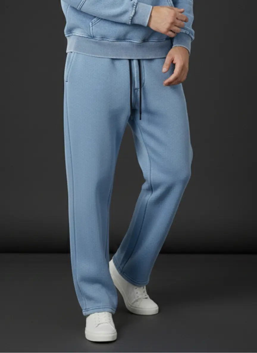 Person wearing a blue tracksuit with white shoes on a dark background