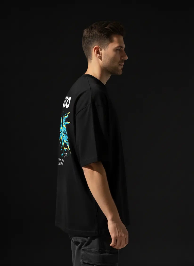 Person wearing a black t-shirt with a colorful graphic on the back against a black background