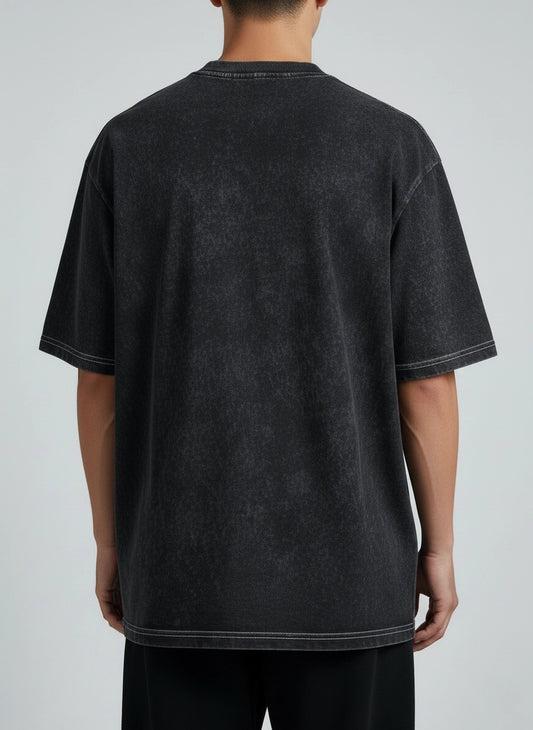 Person wearing a black t-shirt with white trim on a gray background